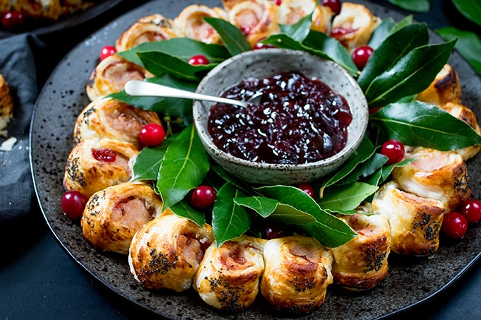 festive sausage roll wreath topped with a honey mustard gaze and poppy seeds