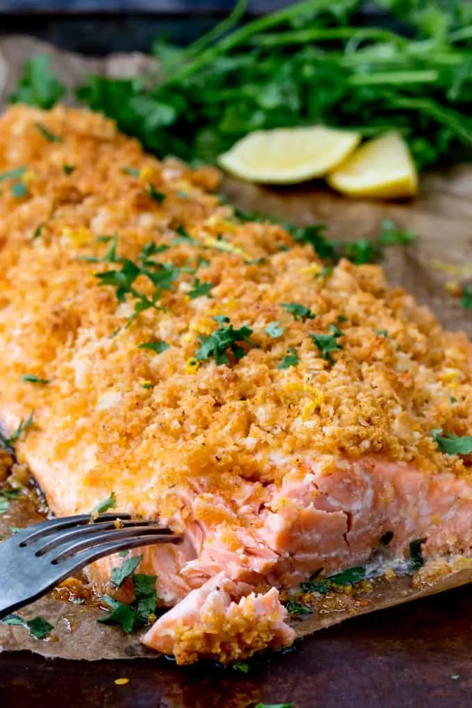 Garlic Bread Crusted Salmon with lemon and herbs in the background