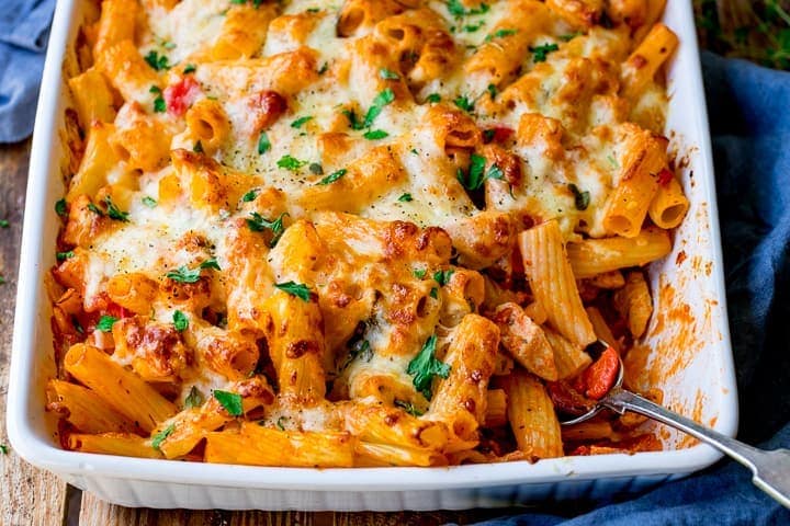 Overhead landscape photo of Cheesy Pasta Bake With Chicken And Bacon in a glass dish