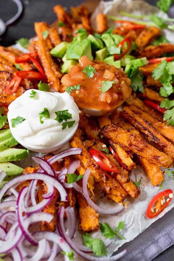 Close up photo of Mexican-style carrot fries with soured cream dip and salsa