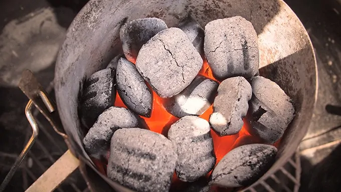 Hot coals in a barbecue chimney starter - heating up for a barbecue