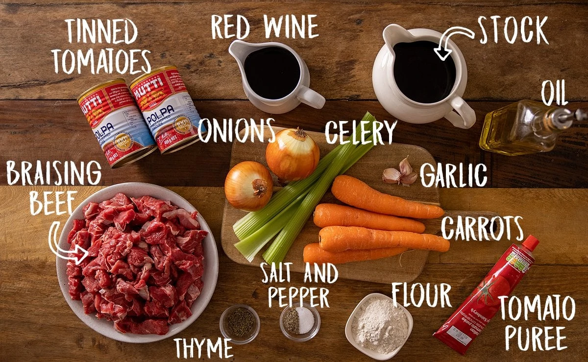 Ingredients for beef ragu on a wooden table