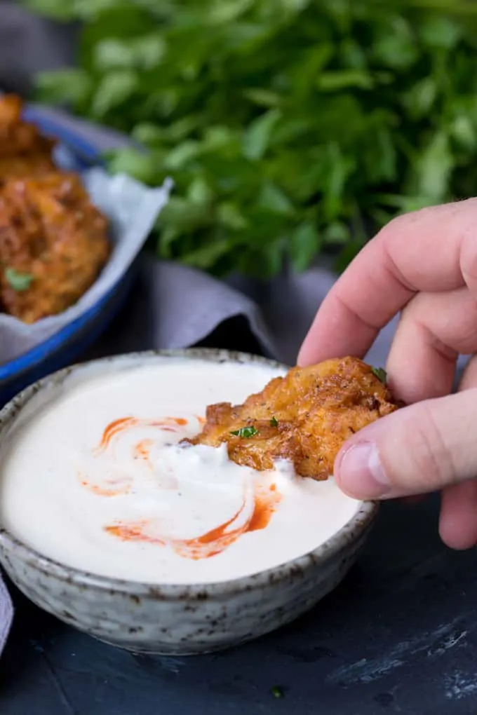 A Crispy Chicken Tender being dipped into garlic chilli mayo