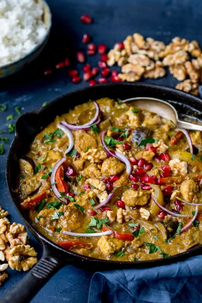 Persian Style Chicken Curry With Walnuts and Pomegranate in a cast iron skillet