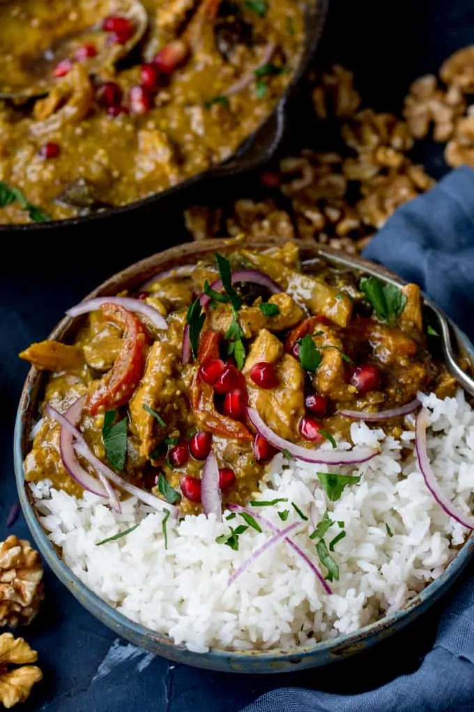 Persian Style Chicken Curry With Walnuts and Pomegranate in a bowl with rice