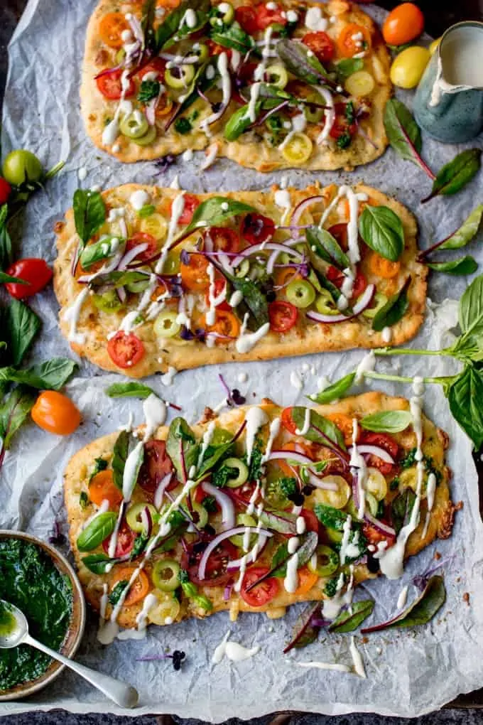 This Vegetarian Summer Tomato Pizza with Basil Garlic Butter and creamy cashew drizzle is a meal even the meat-eaters will love. The homemade no-knead, no-prove flatbread base is super quick to make!