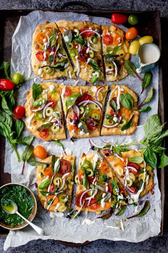 This Vegetarian Summer Tomato Pizza with Basil Garlic Butter and creamy cashew drizzle is a meal even the meat-eaters will love. The homemade no-knead, no-prove flatbread base is super quick to make!