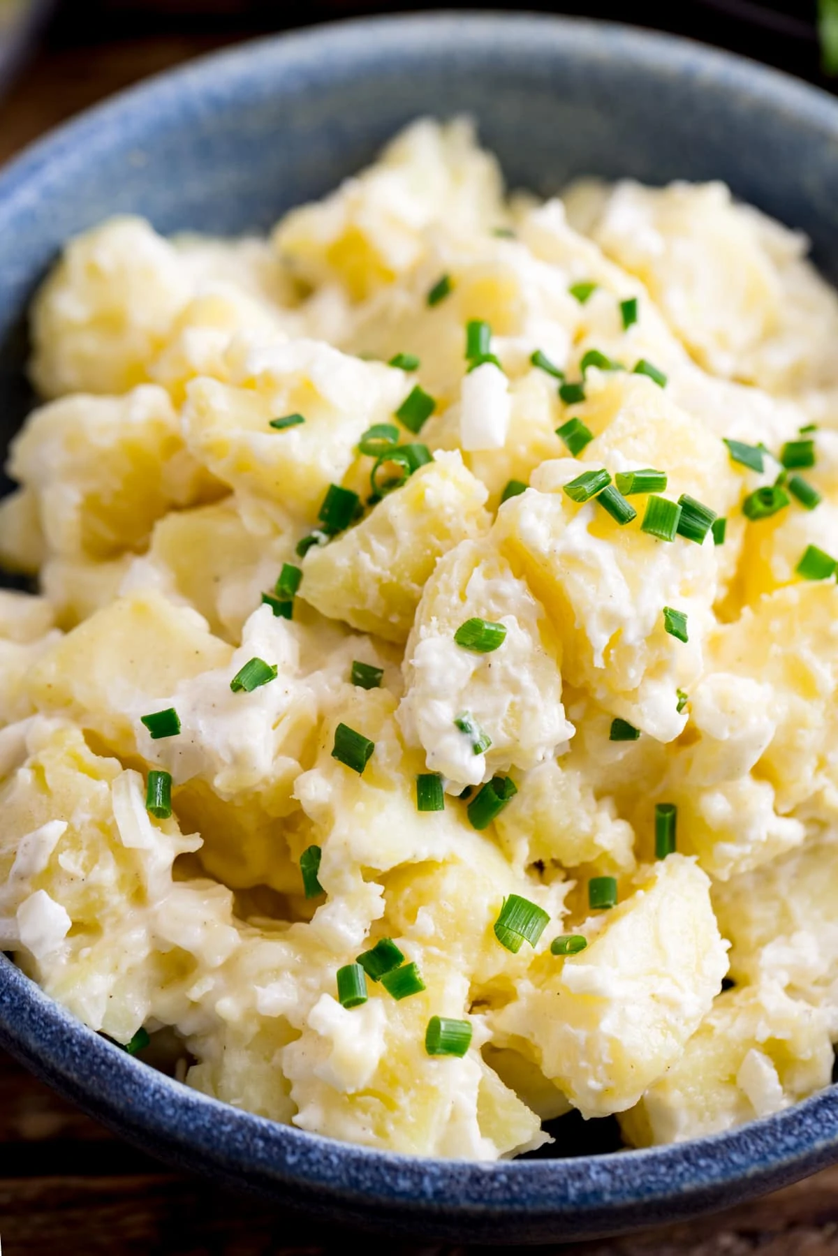 Close up of a blue bowl filled with potato salad.