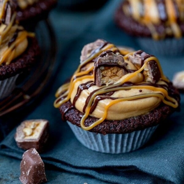 These Chocolate Snickers Cupcakes have a light and fluffy chocolate muffin base, topped with peanut butter frosting and little chunks of Snickers!