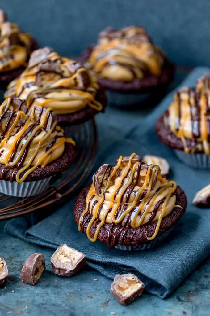 These Chocolate Snickers Cupcakes have a light and fluffy chocolate muffin base, topped with peanut butter frosting and little chunks of Snickers!