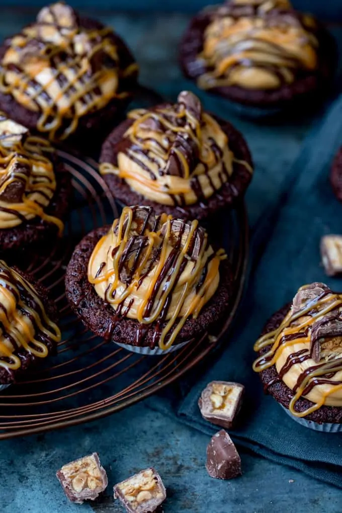 These Chocolate Snickers Cupcakes have a light and fluffy chocolate muffin base, topped with peanut butter frosting and little chunks of Snickers!