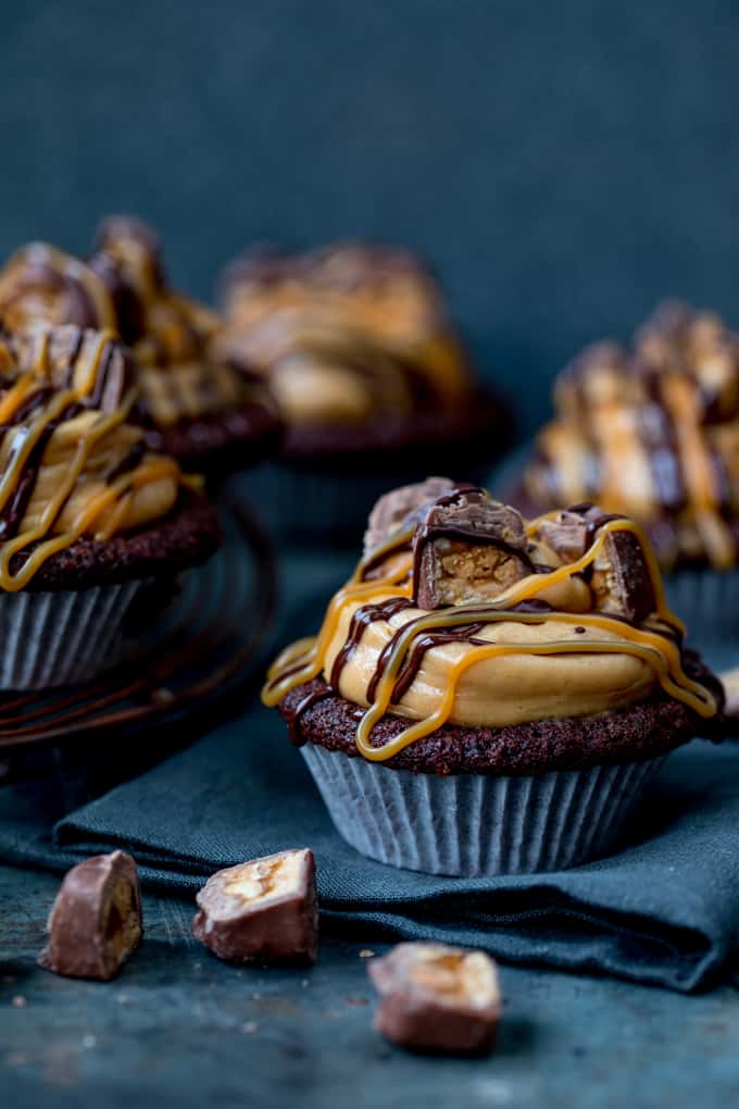 These Chocolate Snickers Cupcakes have a light and fluffy chocolate muffin base, topped with peanut butter frosting and little chunks of Snickers!