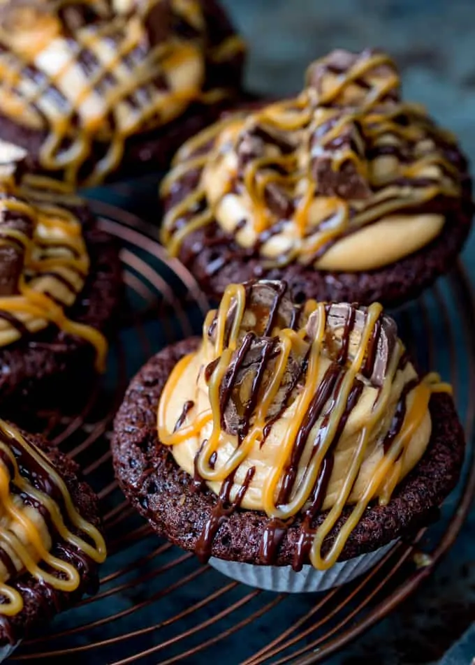 These Chocolate Snickers Cupcakes have a light and fluffy chocolate muffin base, topped with peanut butter frosting and little chunks of Snickers!