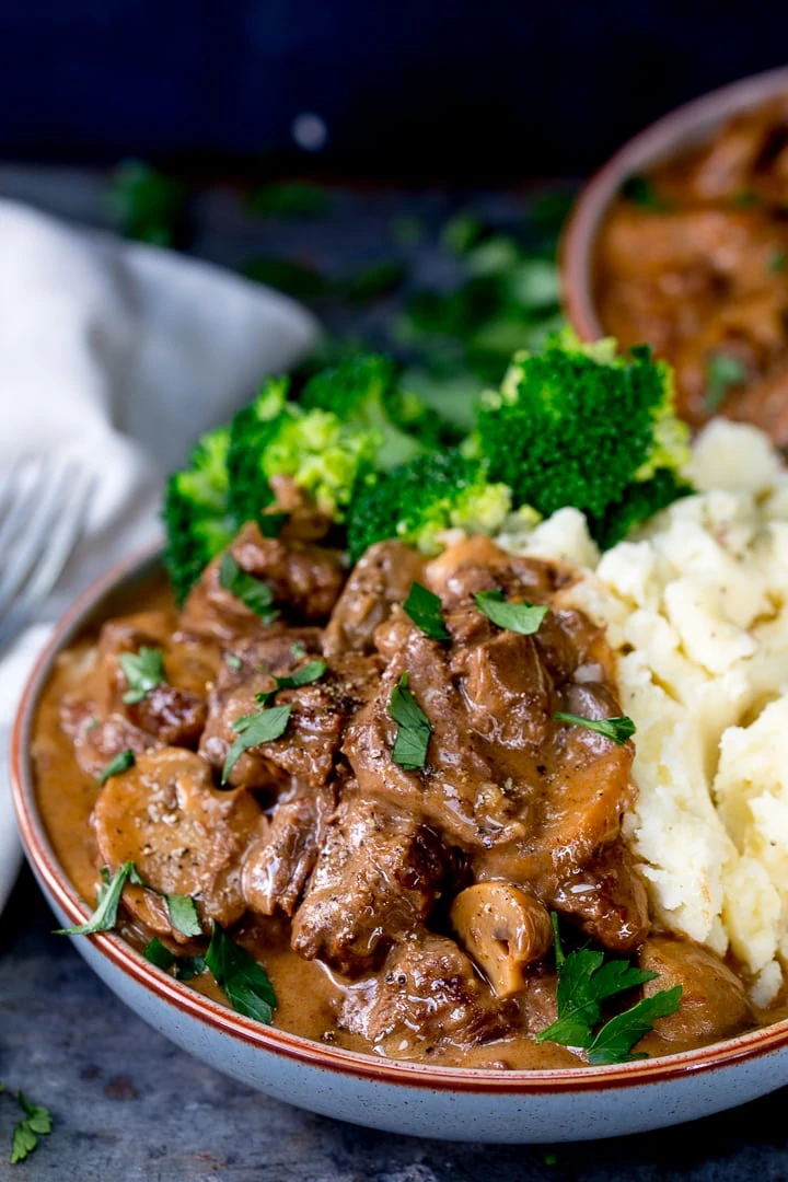 steak diane casserole in a bowl with mashed potato and broccoli