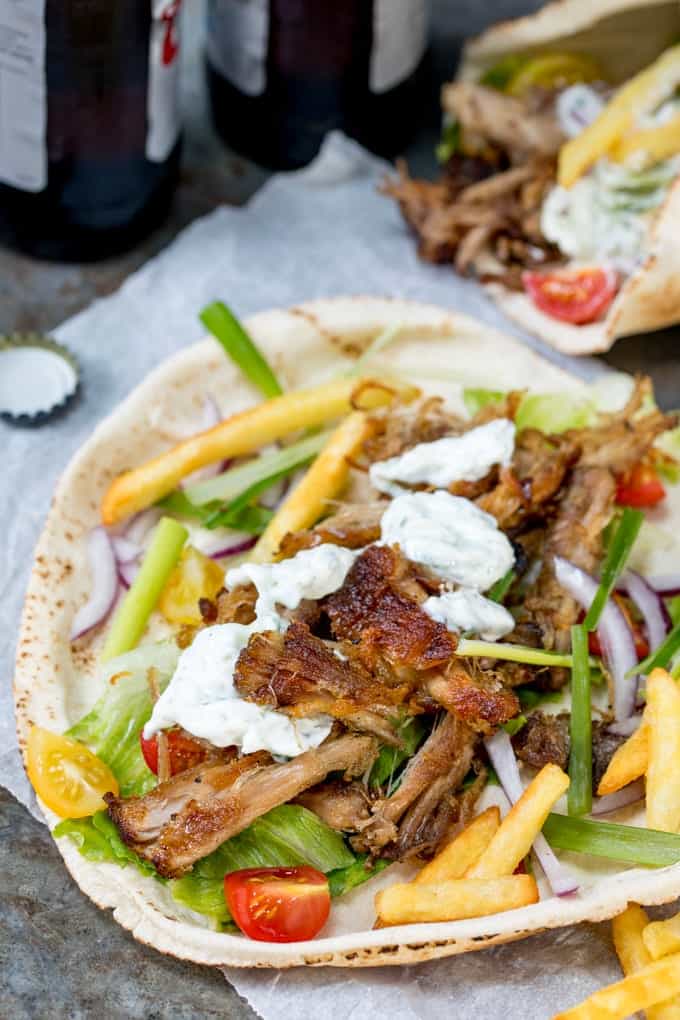 Crispy pork gyros wrapped in a flatbread with lettuce, tomato and red onion