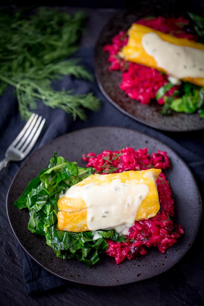 Smoked Haddock with Beetroot Risotto and Garlicky Greens on a black plate