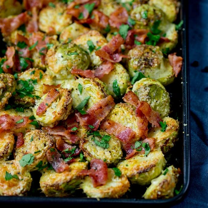 Square image showing rray of roasted sprouts with bacon bits