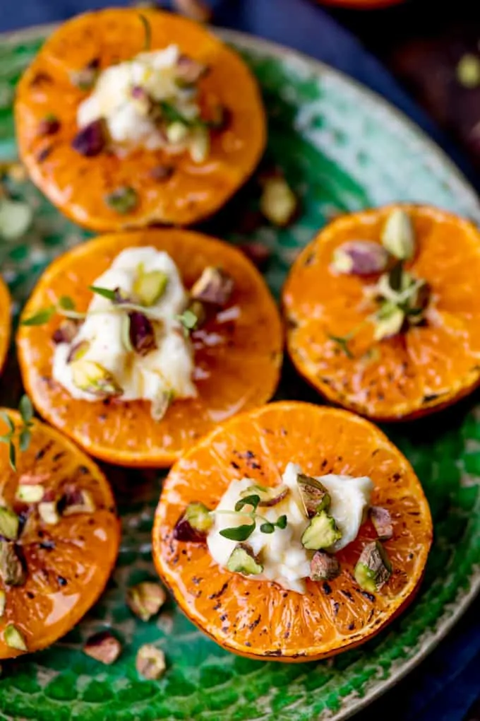 Brown Sugar Glazed Clementines with Cream Cheese, Honey and Pistachios on a green plate