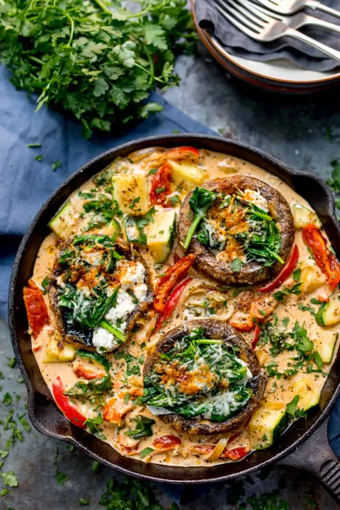 Overhead photo of Tuscan Style Stuffed Mushrooms in Creamy Sun Dried Tomato Sauce in a skillet