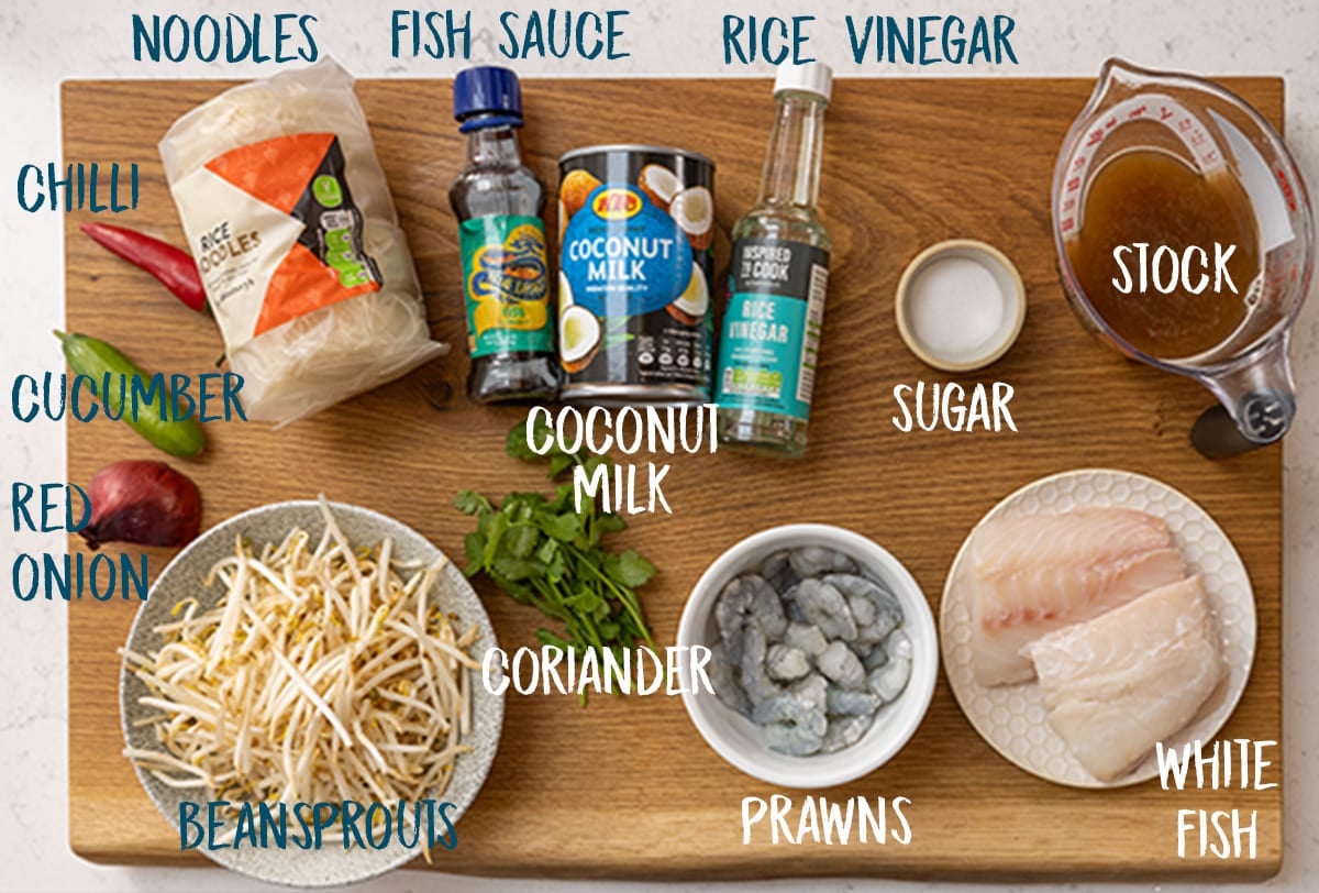 Ingredients for seafood laksa (except for the laksa paste, which can be seen in another image) on a wooden board.