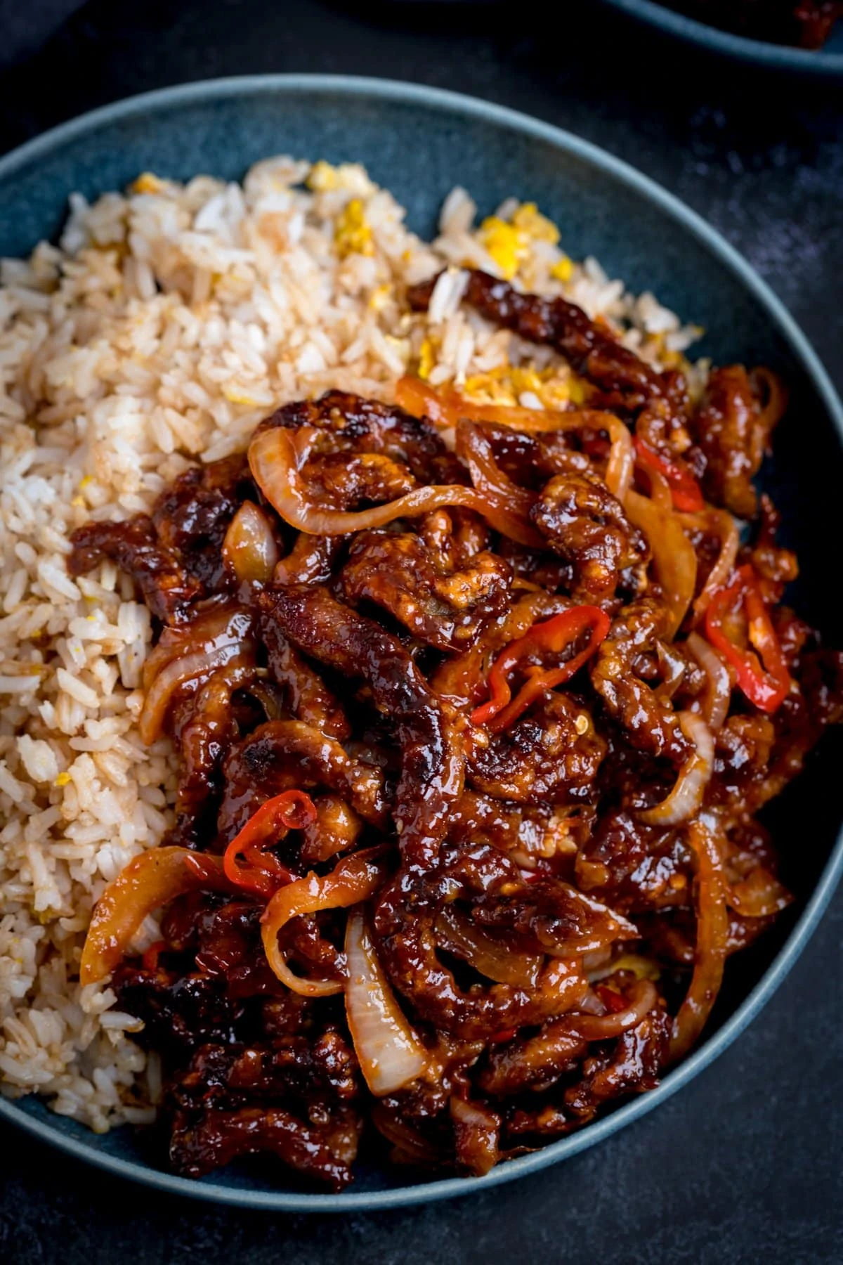 crispy chilli beef in a blue bowl with egg fried rice