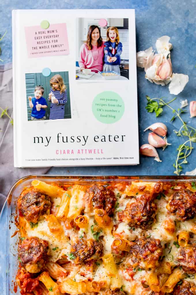 My Fussy Eater cookbook showing meatball pasta bake recipe. Dish of meatball pasta bake next to book.