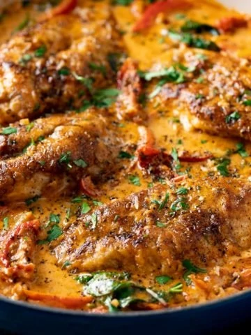 Creamy Tuscan Chicken in a dark pan