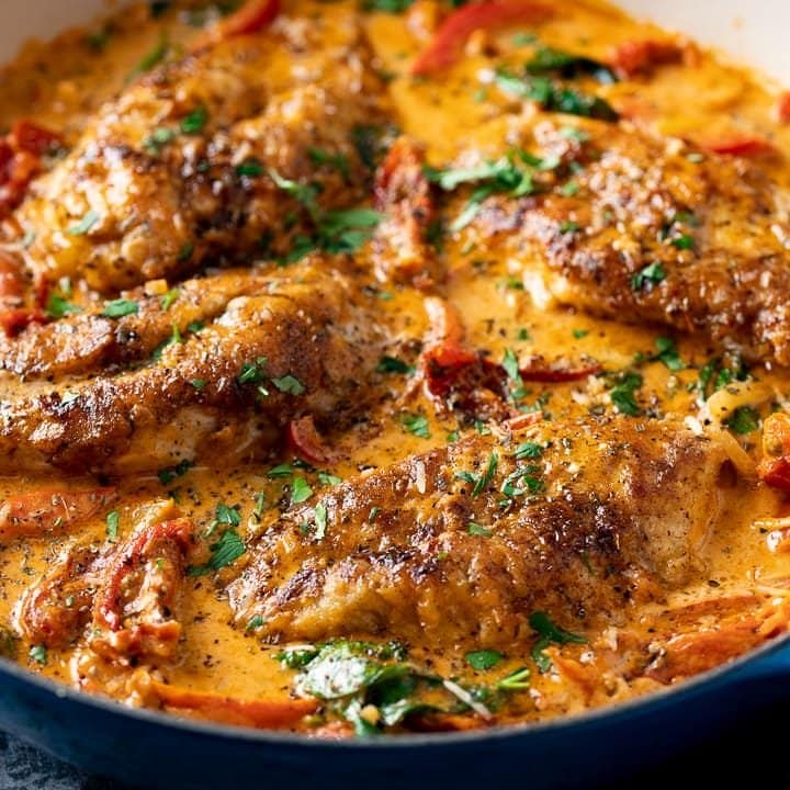 Creamy Tuscan Chicken in a dark pan