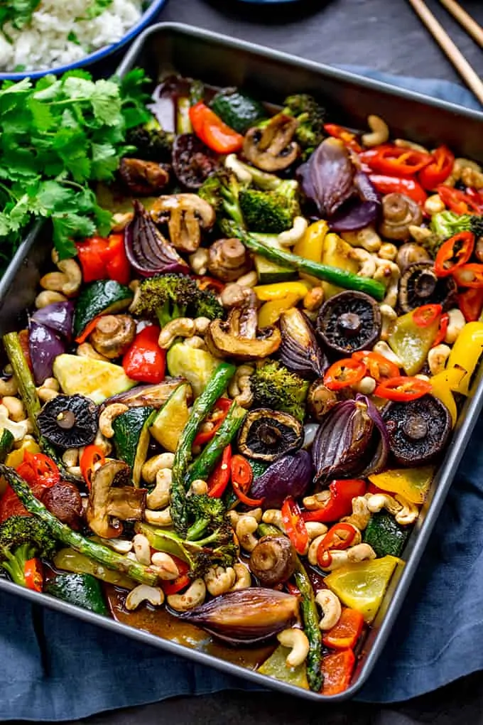 Tray of cooked vegetables in asian sauce with cashews and chillies on top