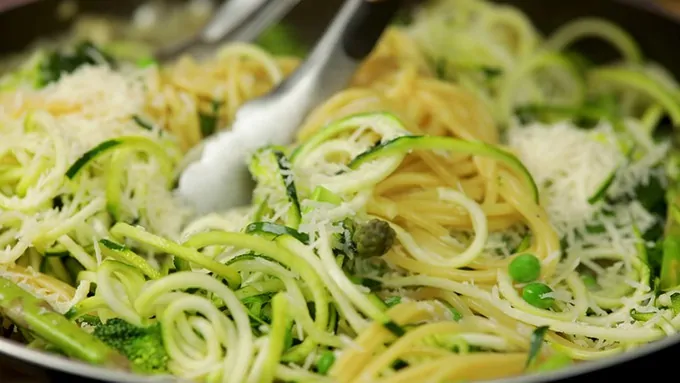 Close up of one pan spring vegetable spaghetti with cheese on top