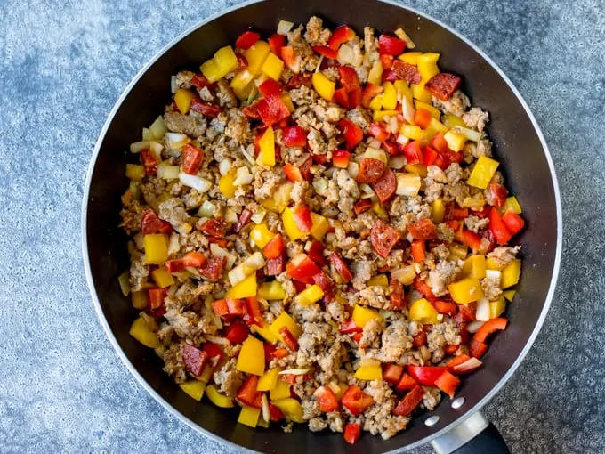 Ground sausage, chorizo, onions and peppers in a pan