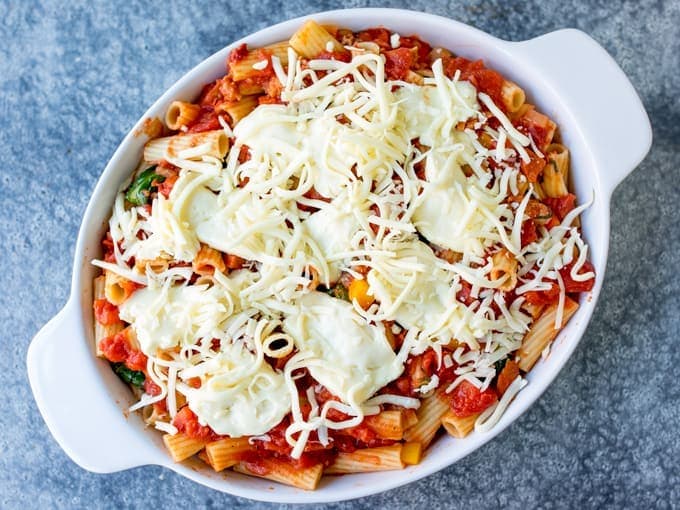 Dish with tomato pasta bake, topped with cheese - before going into the oven