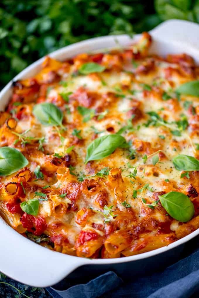 Overhead shot of sausage, chorizo and brie pasta bake with fresh herbs on top.