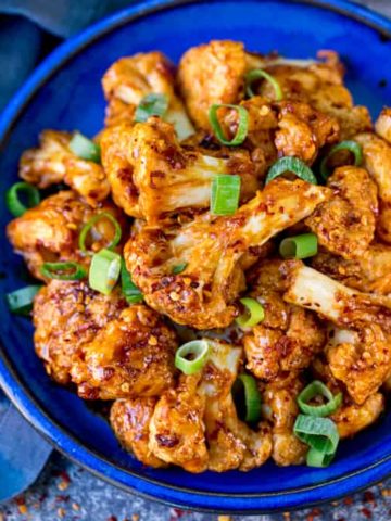 Square photo of Asian cauliflower wings on a blue plate