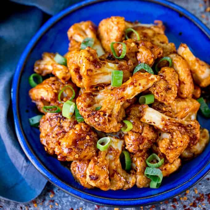 Square photo of Asian cauliflower wings on a blue plate