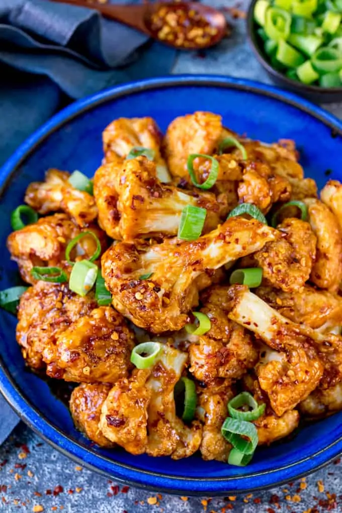 Close up image of Asian cauliflower wings on a blue plate