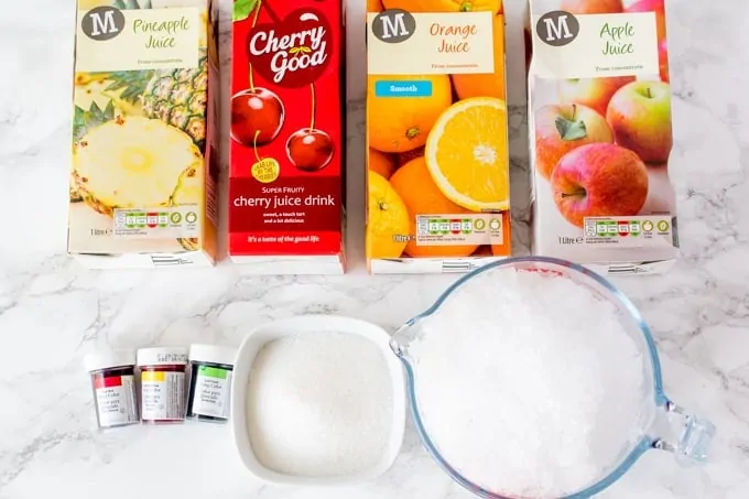 Ingredients for fruit snow cones. These are 4 different fruit juice cartons, ice, sugar, food colouring gel