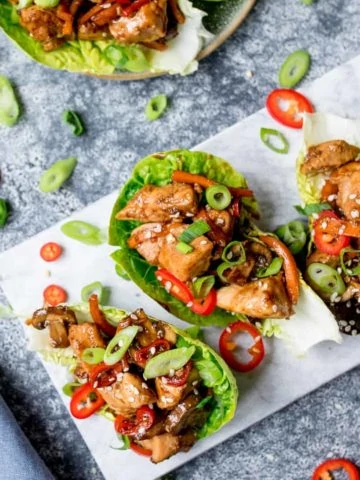 Square image of Asian chicken lettuce wraps in a marble serving board