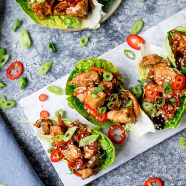 Square image of Asian chicken lettuce wraps in a marble serving board