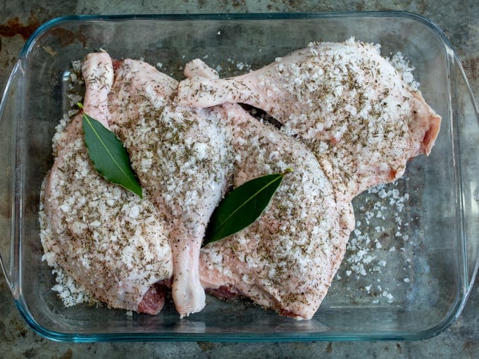 4 raw duck legs covered in salt in a baking dish