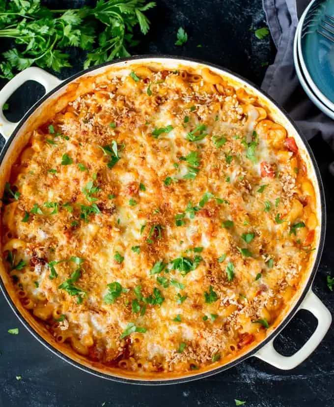 Pan of chicken and bacon mac and cheese with breadcrumb topping on dark background