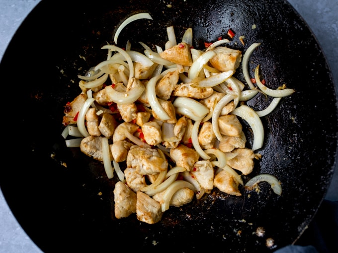 Chicken and onions frying in a wok