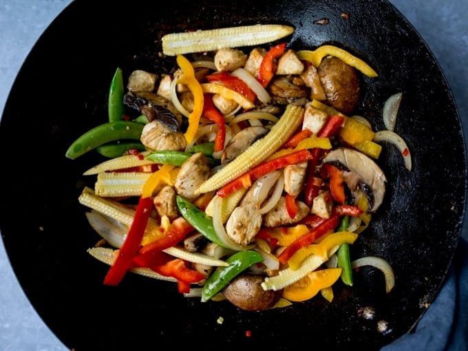 Chicken and vegetables frying in a wok