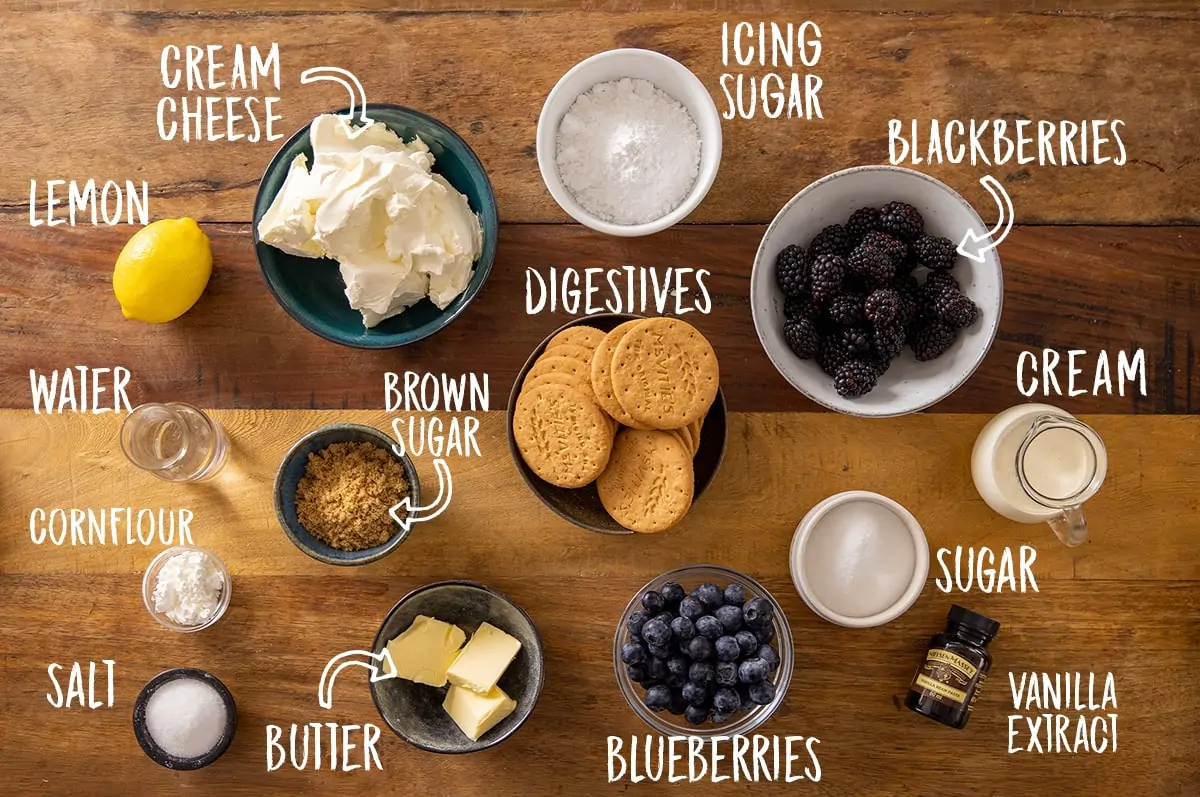Ingredients for individual mason jar cheesecakes on a wooden table