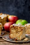 apple streusel cake on a green plate. Apples in the background