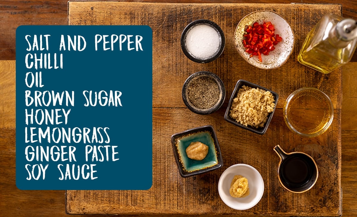 Ingredients for the glaze for sticky Chinese pork belly laid out on a wooden table. There is a list of the ingredients as an overlay in a blue box.