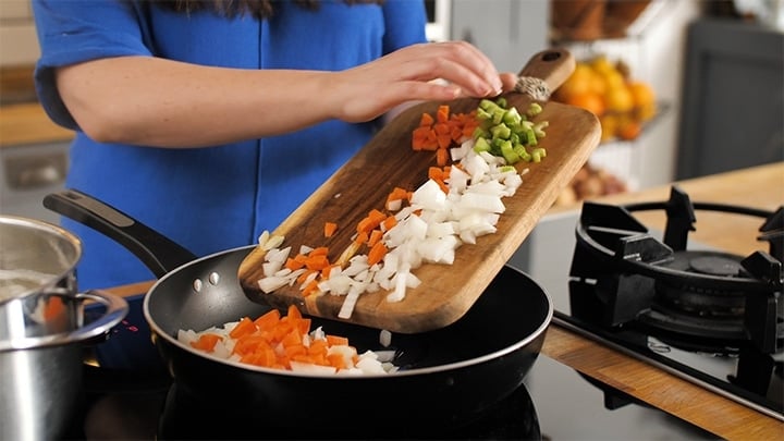 Placing chopped onions, carrot and celery in a pan for cottage pie