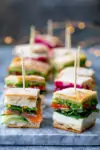Mini sandwich bites with different fillings on a marble platter