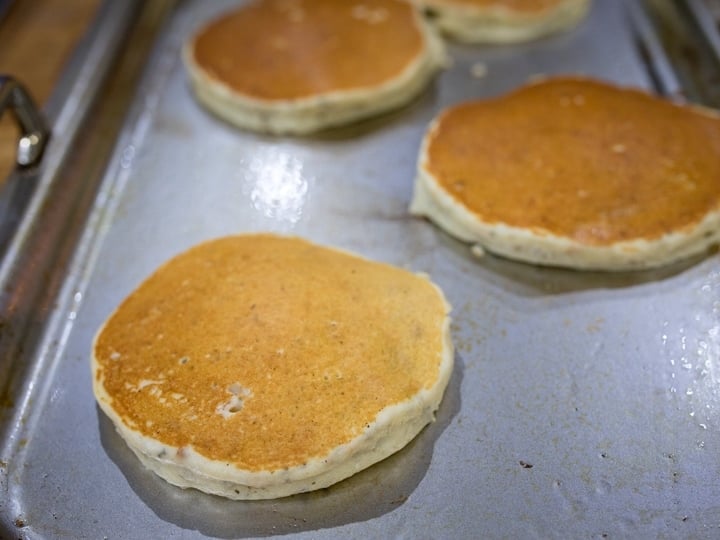 Chia hazelnut pancakes cooking on a griddle - browned on top