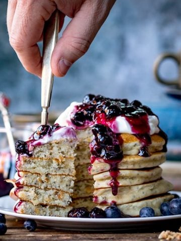 Forkful of Chia hazelnut pancakes with blueberry compote being taken